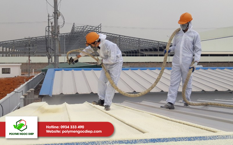 Quá trình phun PU Foam cách nhiệt trần mái nhà xưởng đang được hai nhân viên hoàn thiện